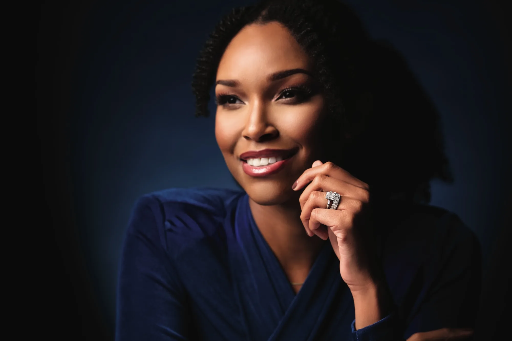 Woman smiling wearing a diamond halo ring